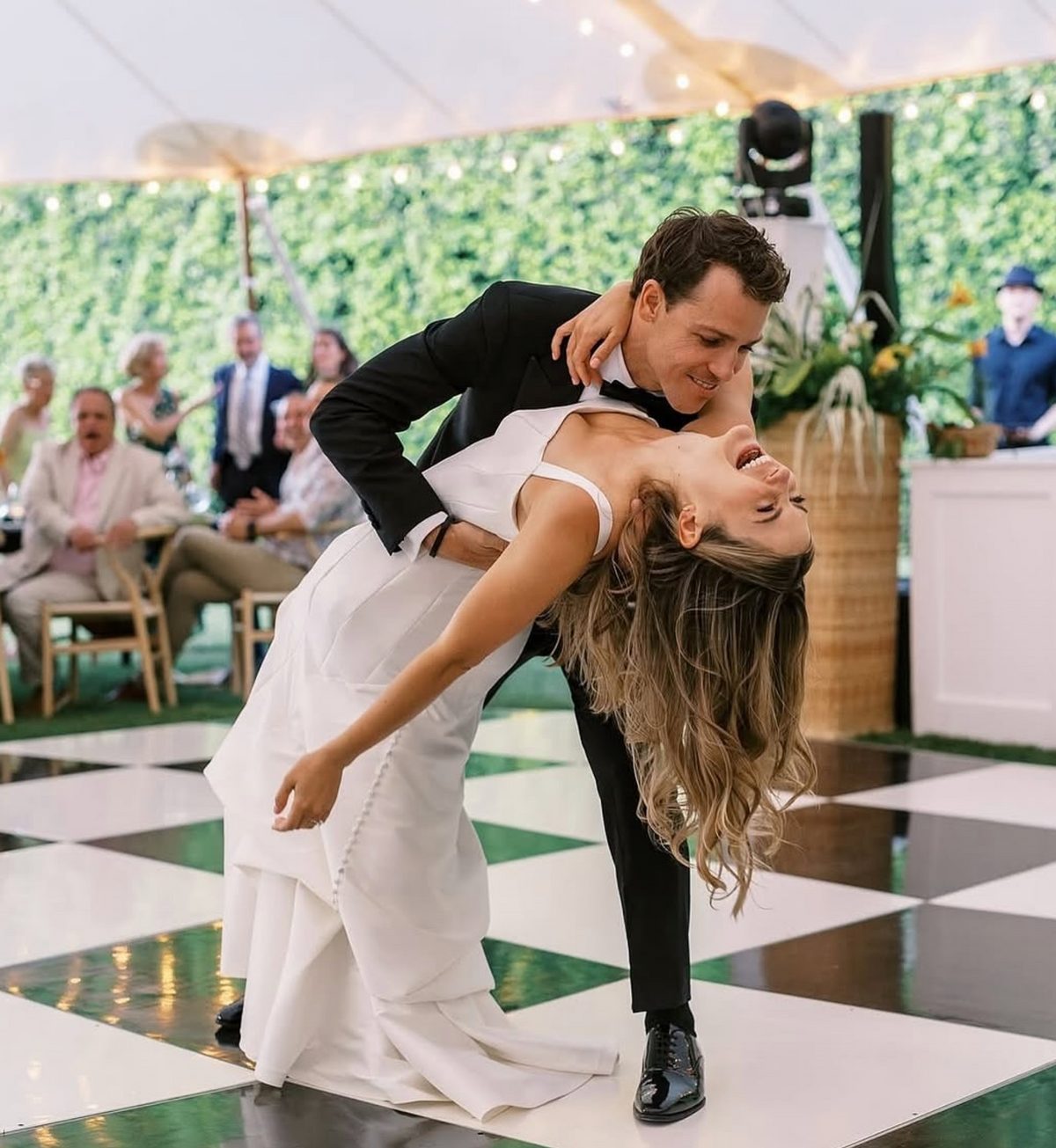 A wedding couple sharing a kiss on a black-and-white tiled patio at Villa Royale.